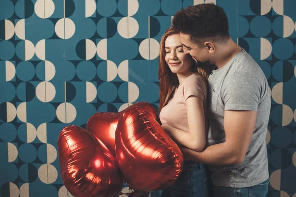 Vit man omfamnar sin fru och ger henne ballonger på en dejt leende tillsammans — Stockfoto