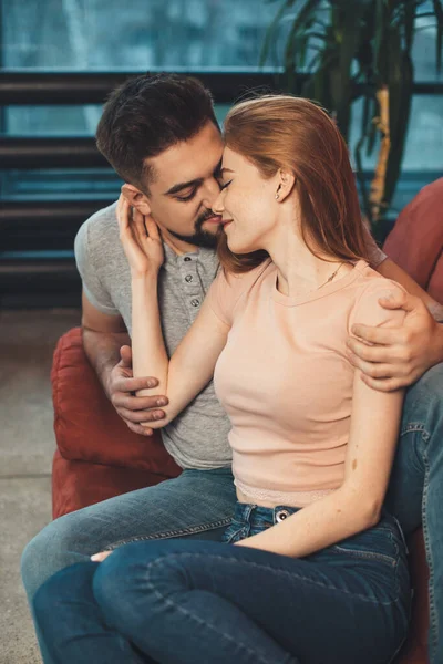 Blank paar zitten op een rode bank omarmen en vieren van een date samen — Stockfoto