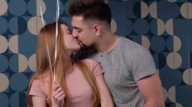 Beyaz adam sevgililer gününde ona balon verdikten sonra karısını öpüyor.