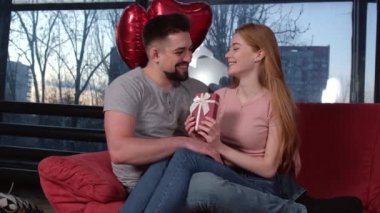 Kafkasyalı bir adamın sevgilisine hediye verirken ve sevgilisine sevgililer gününde balon verirken ön planda görüntüsü.