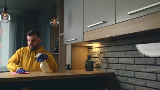 Blanke man gebruikt handschoenen en veegt het huis schoon met speciale spray — Stockvideo