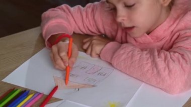 Çocuksu bir kızın kağıda resim çizdiği ve pembe elbiseler giydiği bir video.