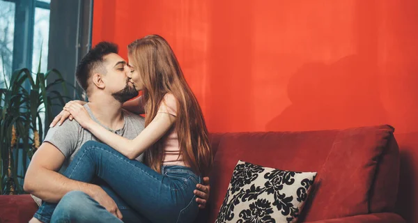 Uomo caucasico che tiene la sua donna zenzero sulle gambe e la bacia celebrando insieme il giorno di San Valentino — Foto Stock