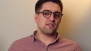 Gözlüklü beyaz adam kameraya konuşuyor ve online dersler sırasında bazı iş fikirlerini anlatıyor.