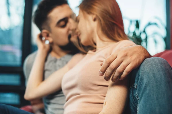 Casal caucasiano relaxante em um sofá juntos beijando e abraçando — Fotografia de Stock