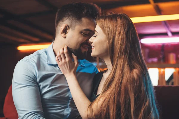 Photo rapprochée d'une femme rousse caucasienne embrassant son amant et souriant assis sur un canapé — Photo