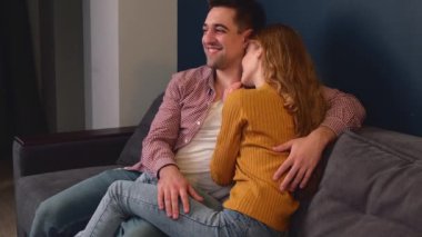 Kızıl kadın kanepede birlikte vakit geçirirken sevgilisini kucaklıyor.