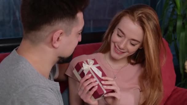 Běloška zázvor žena s pihami se usmívá, zatímco drží její dárek od milence dívá na něj — Stock video