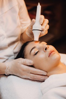 Yüzündeki kaplıca salonundaki beyaz bir kadına yapılan cilt bakımı işlemi.