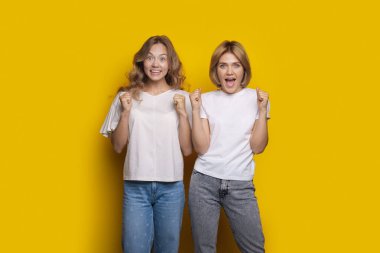 Beyaz kadın, sarı duvarda duran ve yumruklarıyla el kol hareketi yapan bir şeye şaşırır.