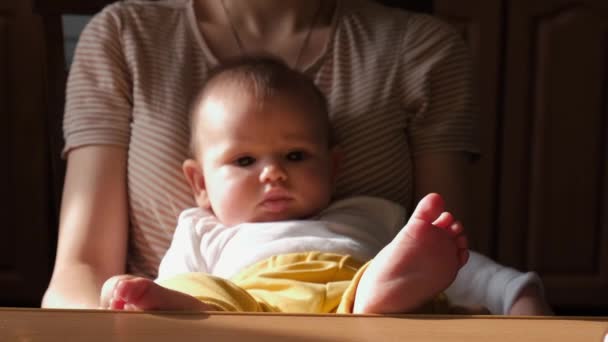 Adorable nouveau-né est tenu par sa mère tenant les jambes sur la table — Video