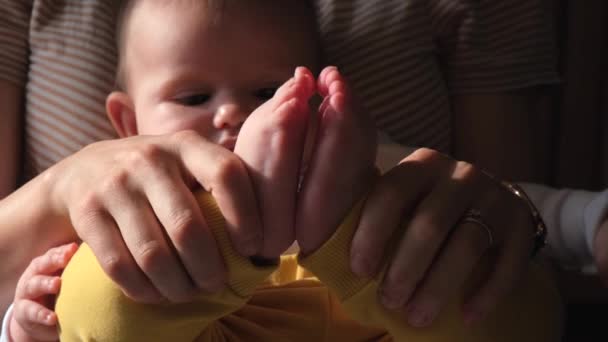 Härlig mamma leker med sina nyfödda bebisben — Stockvideo