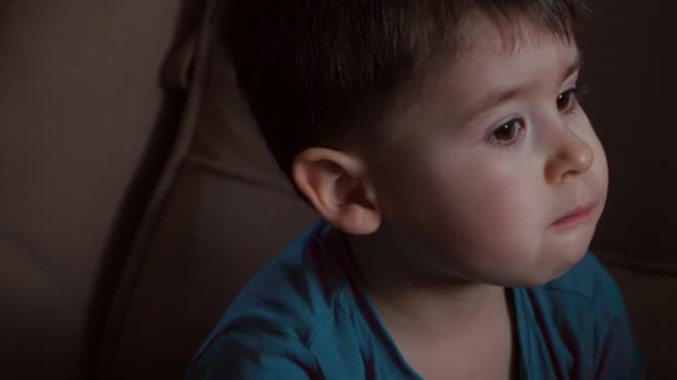 Маленький кавказский мальчик ест виноград и смотрит в камеру, думая о чем-то — стоковое видео