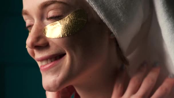 Веснушчатая женщина с рыжими волосами улыбается в золотых повязках на глазах — стоковое видео