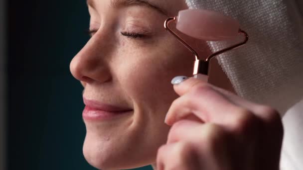 Mulher de gengibre com sardas está massageando seu rosto com um rolo derma sorrindo — Vídeo de Stock