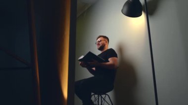 Genç işadamı toplantı sırasında elinde bir kitapla gülümsüyor.