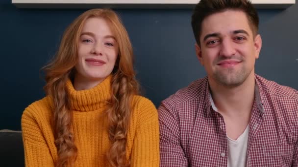 Kaukázusi mosolygós pár online beszél valakivel, aki a kanapén ül és kamerát hallgat. — Stock videók