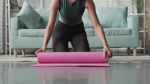Caucasian woman is finishing her yoga session gathering her mat and smiling at camera — Stock Video