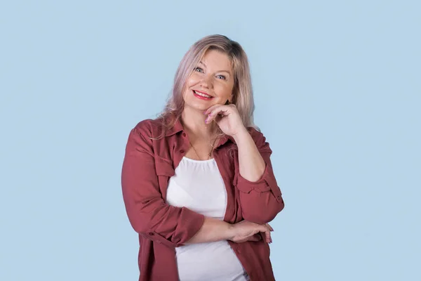 Blonde senior femme d'affaires pose sur un mur bleu studio souriant à la caméra — Photo