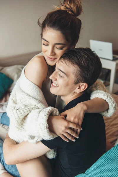 Cute woman embracing her lover is smiling while cheering in bed with him — Stock Photo, Image