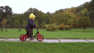 Beyaz çocuk, bir sonbahar günü yeşil bir parkta bisiklet sürerken ailesi tarafından filme alınır.