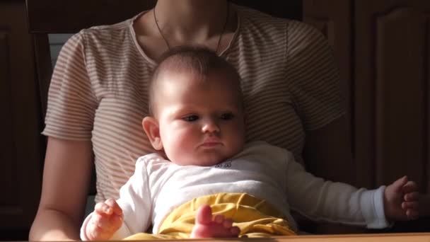 Кавказская мать держит своего новорожденного ребенка за столом, готового кормить — стоковое видео