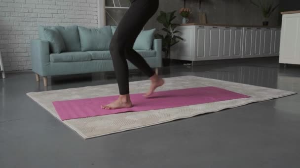 Γυμναστική ασκείται από μια αθλητική γυναίκα στο σπίτι για γιόγκα χαλί — Αρχείο Βίντεο