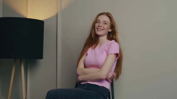 Adorable student with red hair and freckles is smiling sitting on a chair — Stock Video