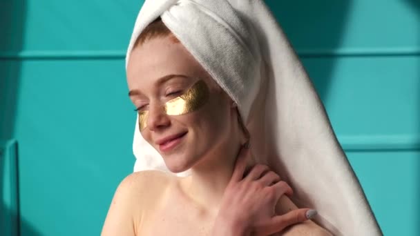 Adorable woman with eye patches is smiling at camera during spa procedures at home — Stock Video