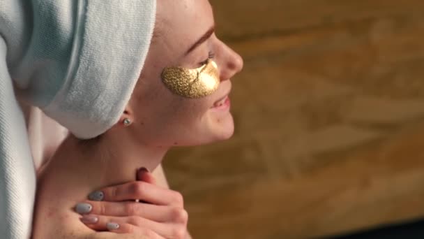 Boční pohled video kavkazské ženy na sobě zlaté pásky přes oko s úsměvem — Stock video