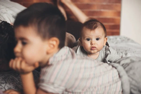 Keluarga Kaukasia berbaring di sofa menghabiskan waktu bersama-sama sementara bayi yang baru lahir sedang melihat kamera — Stok Foto