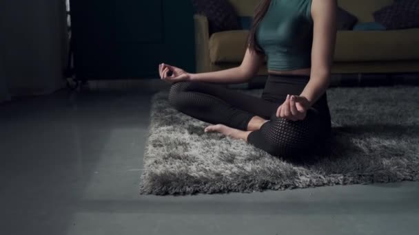 Koncentrerad på meditation kvinna sitter på flor poserar vid kameran — Stockvideo