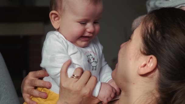 Adorable madre caucásica sosteniendo al bebé recién nacido sobre ella y jugando con ella — Vídeos de Stock