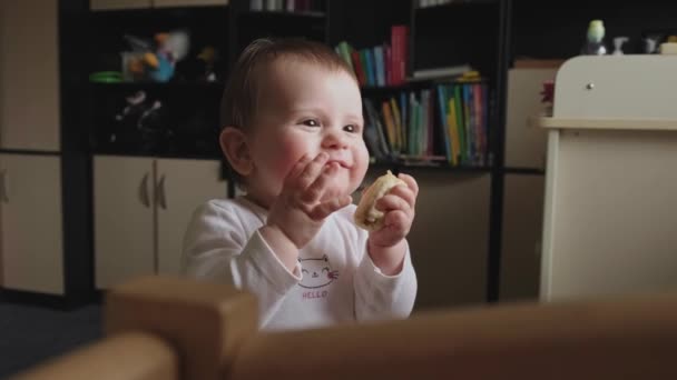 Video with a happy baby girl sitting on the floor and eating banana with  appetite. Closeup portrait. Beautiful girl. Family care. Baby care. — Stock  Video © dekazigzag #543510148