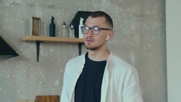 Jeune homme caucasien a une réunion en ligne de la maison parler sur les écouteurs — Video