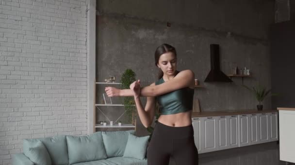 Caucasian slim woman is warming up before a fitness session at home — Stock Video