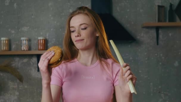 Ginger woman with freckles is making a hard decision between junk food and natural salad — Stock Video