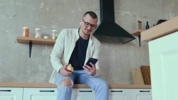 Běloch používá telefon, zatímco pracuje doma v kuchyni během obchodní schůzky — Stock video