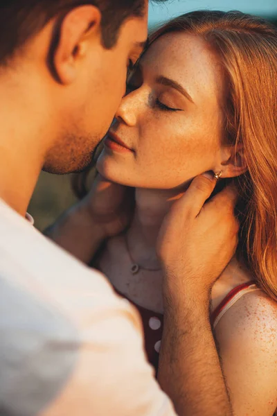 Close up photo of a caucasian ginger woman with freckles kissing and embracing in the sunshine — Stock Photo, Image