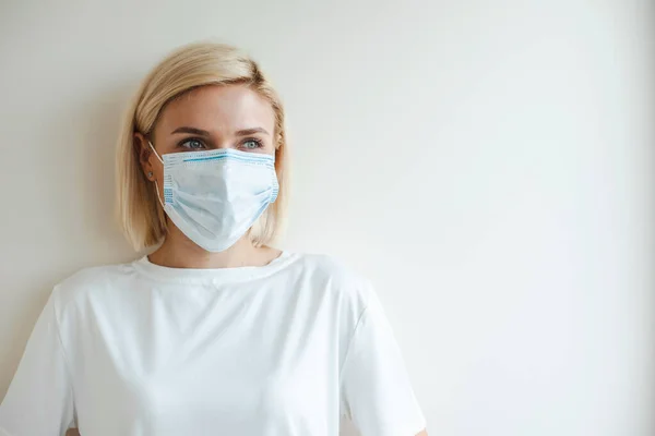 Blonde woman wearing medical mask. Coronavirus health problem. Virus protection. Pollution prevention. Health care. — Stok Foto