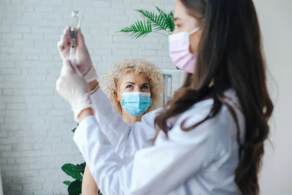 Dokter menyiapkan vaksin menggunakan sarung tangan dan masker. Perlindungan Virus. Vaksin kesehatan medis. Tes Covid. — Stok Foto