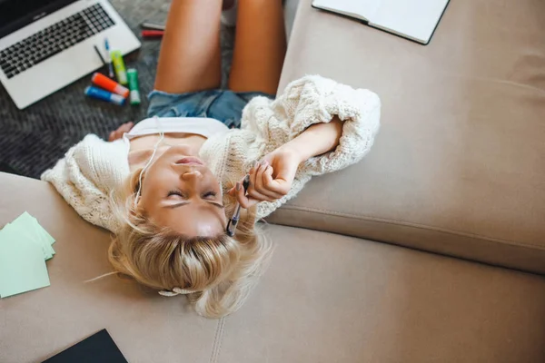 Mujer usando laptop y sintiéndose cansada en el suelo. Educación en línea. Educación en el hogar durante el encierro. — Foto de Stock