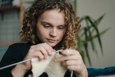 Genç bir insan örgü örmekten, yaratıcılığını göstermekten ve barışı teşvik eden rahat bir ortamda dinlenmekten hoşlanır.