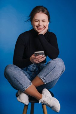 neşeli bayan öğrenci cihazla rahatlıyor, neşeli genç bayan dışarıda eğleniyor.