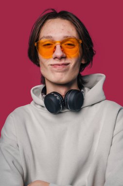 Şık aksesuarları olan müzik meraklısı, stüdyo fotoğraflarında moda göz ve oyun kıyafetleri sergiliyor.