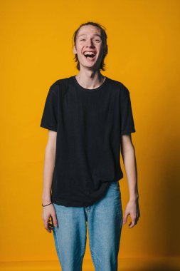 Gençliğin neşeli görüntüsü, enerjik gençlik, pazarlama kampanyaları için dinamik ışıklı stüdyoda mutluluk ve rahatlama yayıyor.