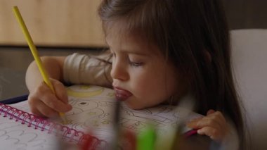 çocuk canlı renklerle meşgul, çocuk tutkuyla kalem ve kalemlerle sanat yaratıyor.