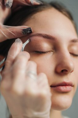 Kaş dövmesi, sakin atmosfer, steril aletler ve pigment alan kapalı gözlü bir müşteri