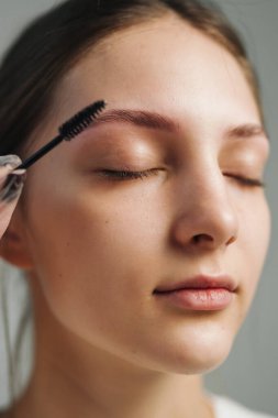 Geniş fırçalı, tüylü, kıvırcık saçlı, jöle yerleştirmenin nazik vuruşları, gözleri olan beyaz bir kadın.