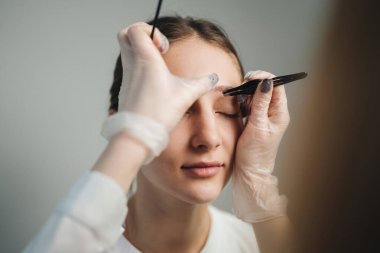 Cımbız, Steril Eldiven, Yumuşak Stüdyo Işık, Gevşetilmiş Cımbız kullanan Makyaj Sanatçısı ile Kapanış Büyüsü Şekillendirme Oturumu